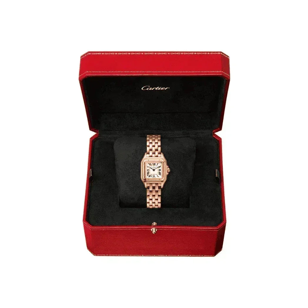 Rose gold women's watch with Roman numerals in a red Cartier box on black velvet.