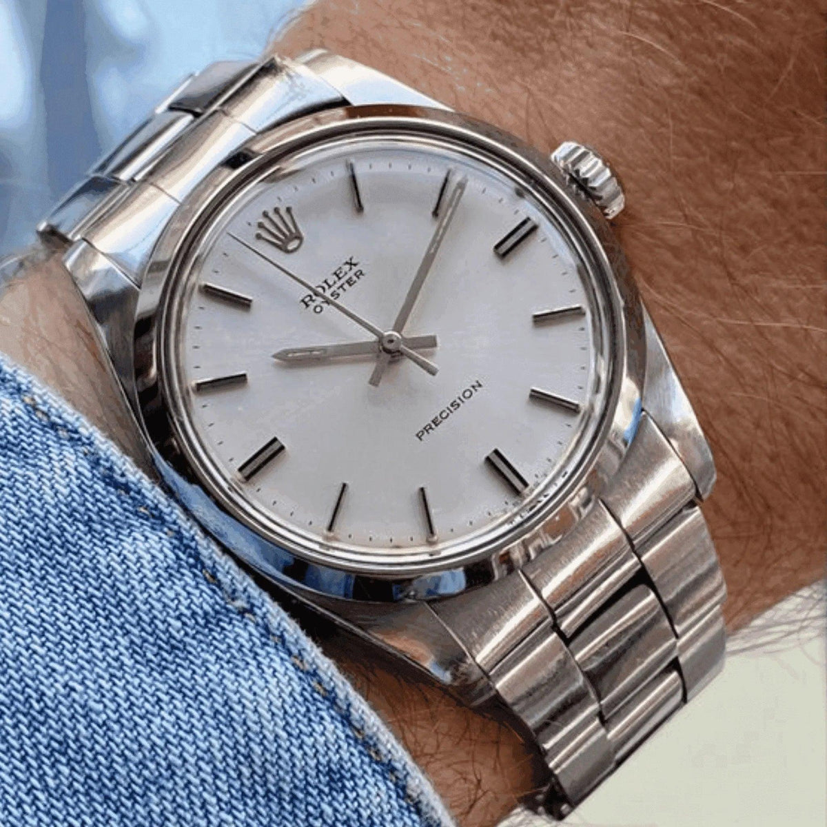 Classic silver men's wristwatch with white dial and metal bracelet on wrist
