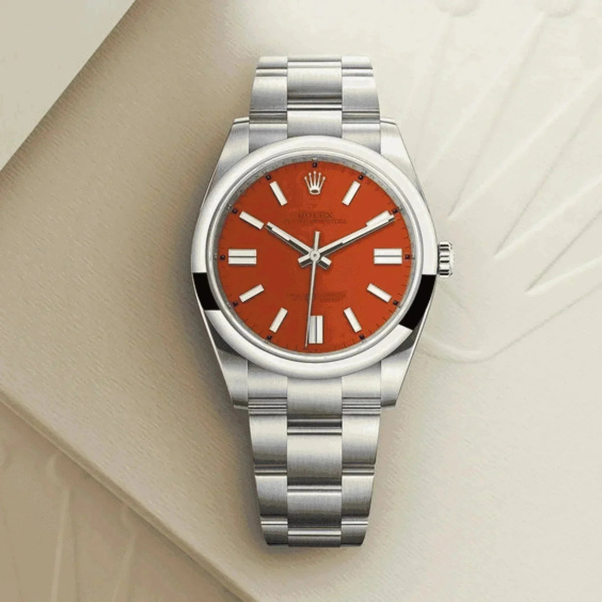 Classic men's stainless steel watch with orange dial on light textured surface