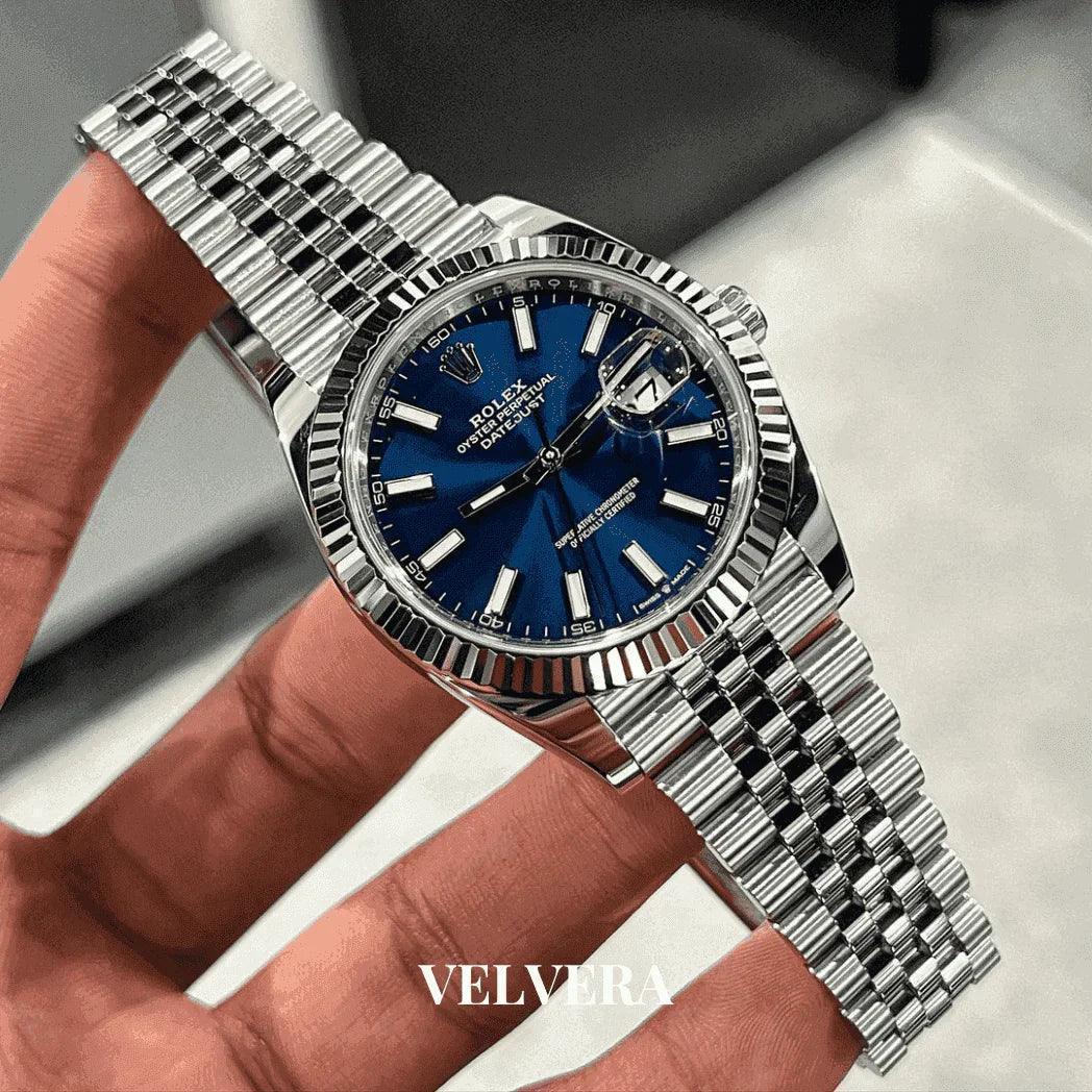 Men's Rolex Datejust 41 watch with blue dial and silver bracelet, held by hand, Velvera