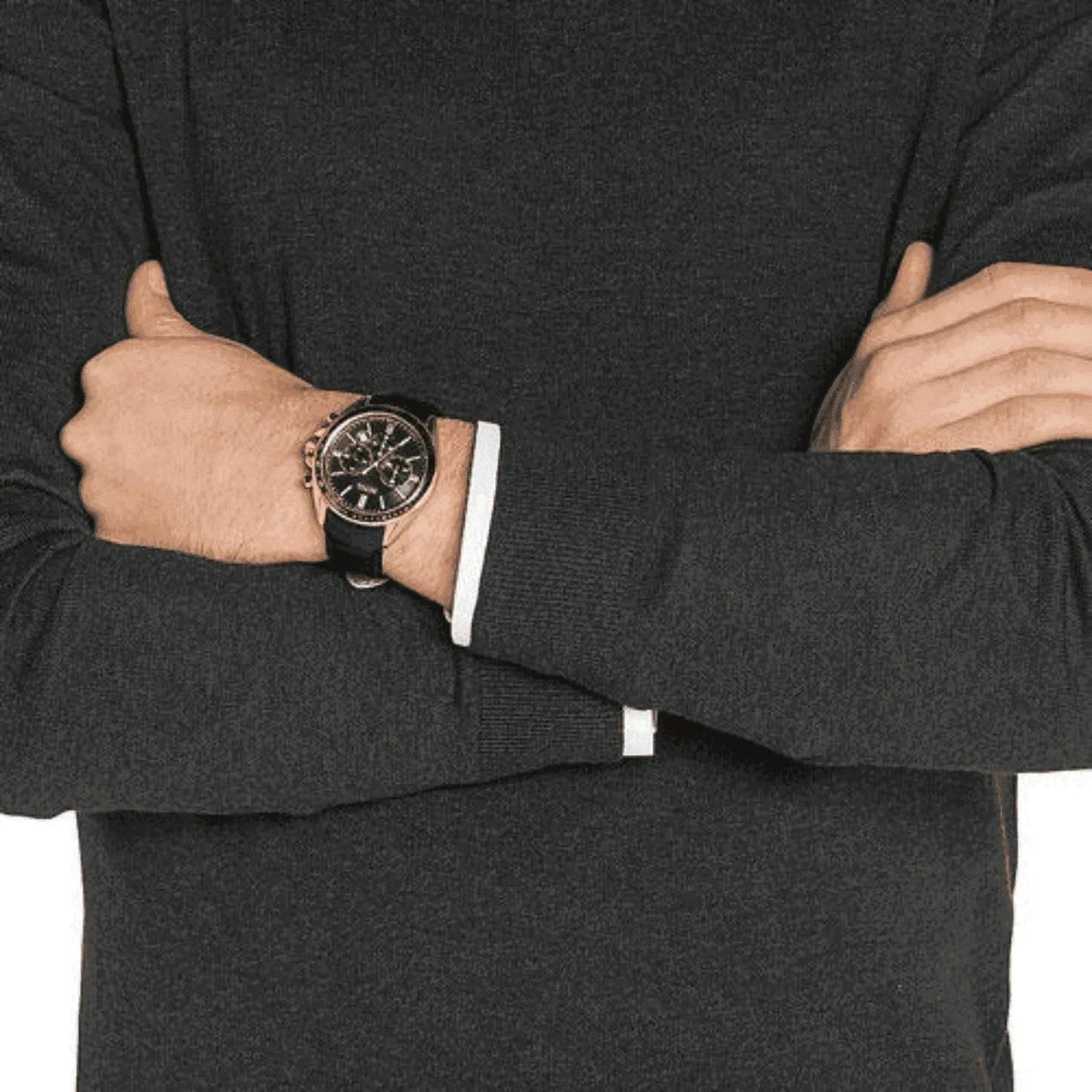 Man wearing black leather chronograph watch with gold case and dark sweater