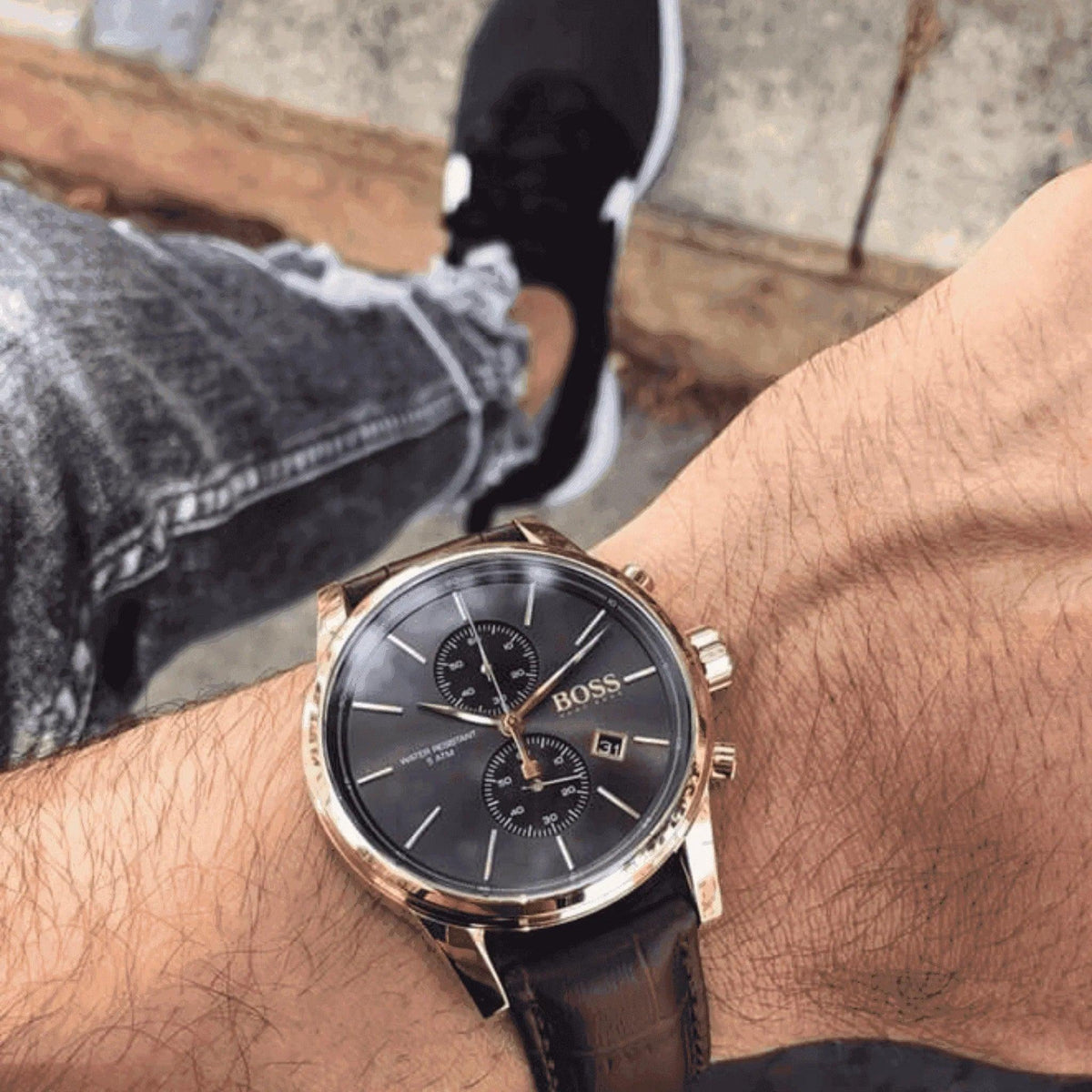 Men's BOSS brown chronograph wristwatch with black dial and leather strap on wrist